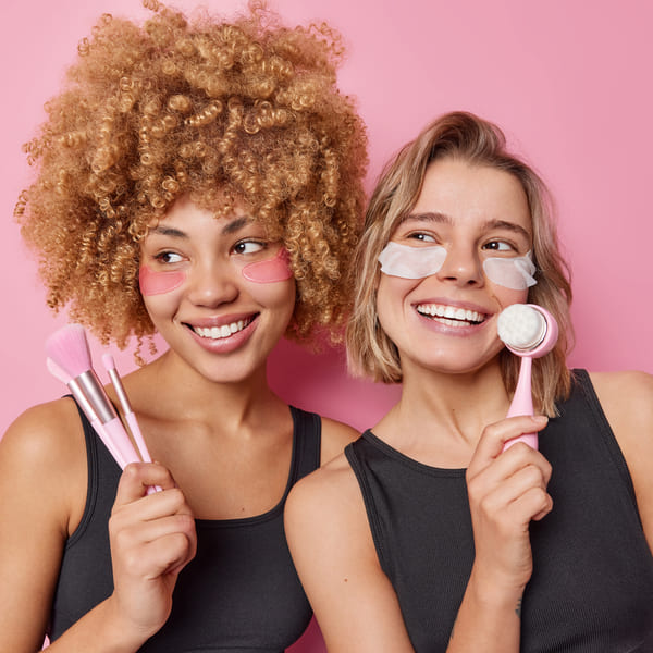 Two girls demonstrate makeup tools